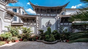 A traditional courtyard with ornate architecture, potted plants, and a clear blue sky. - Jiayu Seascape Inn (Dali City)