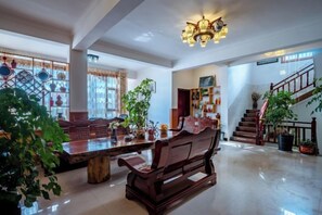 Un salon spacieux avec une table basse en bois, un canapé et un escalier menant à l’étage supérieur.