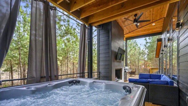 Un jacuzzi en un área de terraza de madera con vistas a árboles.