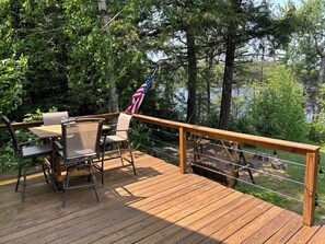 Eine Holzterrasse mit Gartenmöbeln und einer US-amerikanischen Flagge.