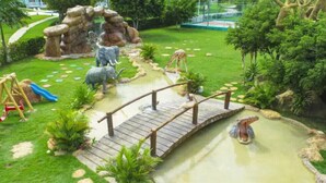 Un giardino curato con un ponticello in legno, uno stagno e statue di animali.