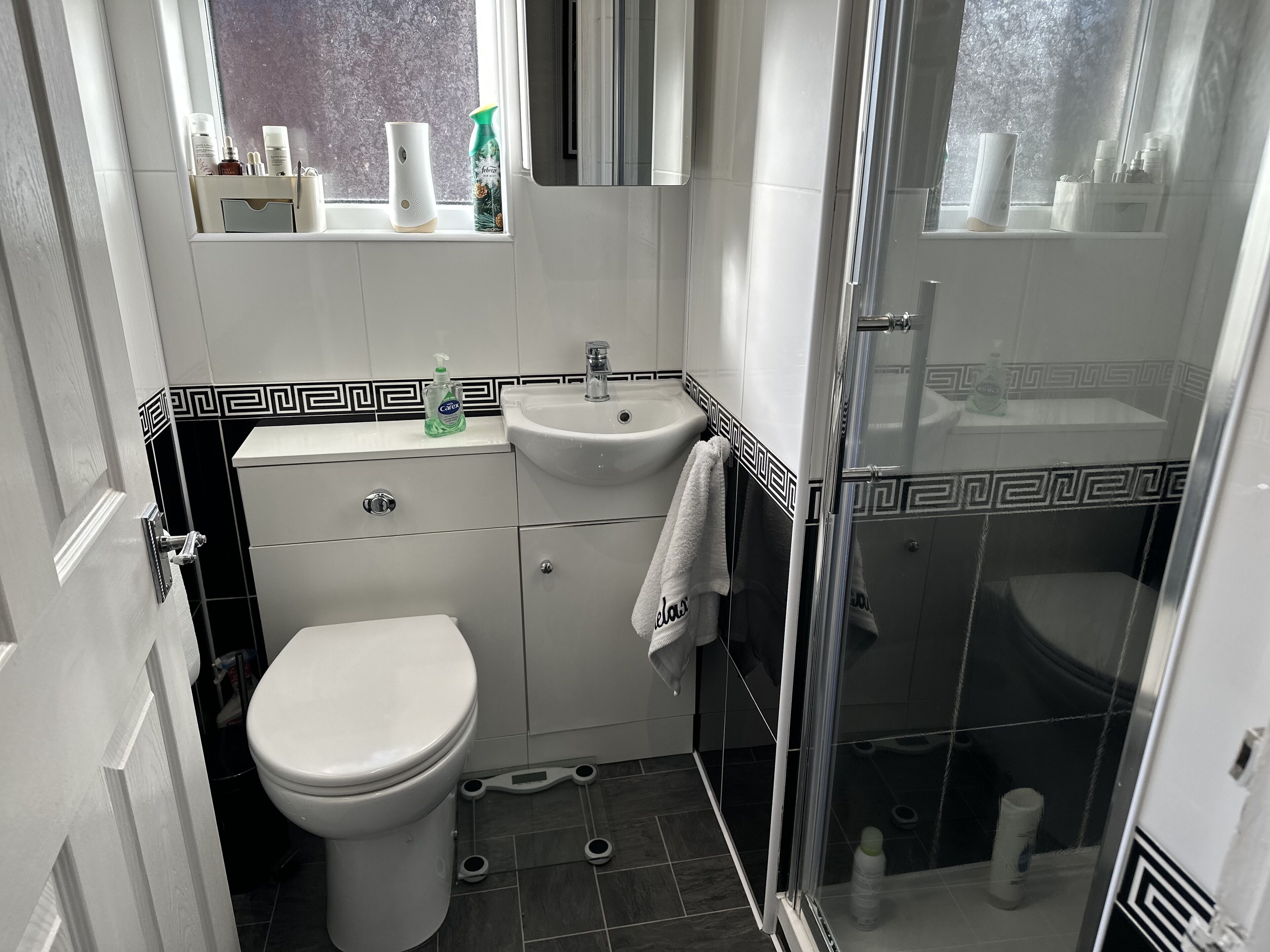 A compact bathroom with a toilet, sink, and shower.