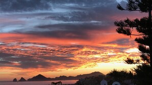 Vista del atardecer en la costa con edificios blancos y cielo despejado.
