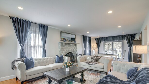 A living room with two sofas, a coffee table, and a fireplace. - Spacious home for entertaining, centrally located to beach, ferry, and airport. (Edgartown)