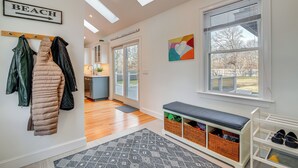 A hallway with a coat rack, a bench, a shoe rack, and a 'BEACH' sign. - Spacious home for entertaining, centrally located to beach, ferry, and airport. (Edgartown)