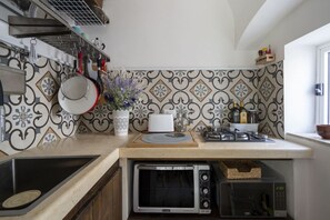 Microondas, placa de cocina, cafetera o tetera y utensilios de cocina