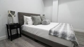 A bedroom with a bed, a nightstand, and a lamp.