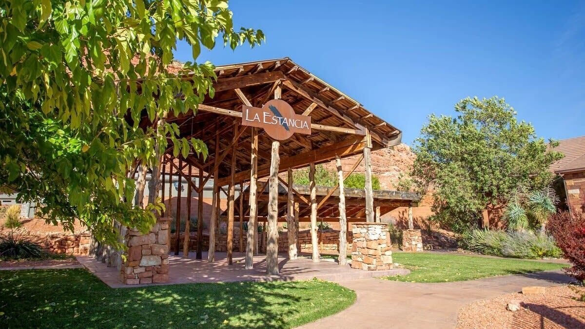 A rustic wooden pavilion with a sign reading "La Estancia".