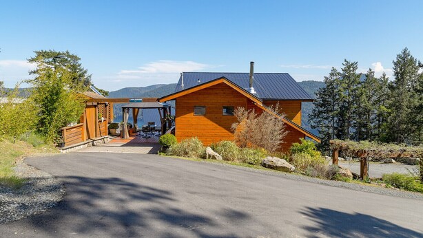 A cabin with a covered outdoor seating area, a view of the mountains, and a clear sky. - Two-Bed Cabin – Breathtaking Fjord View at the Summit House. (Malahat)