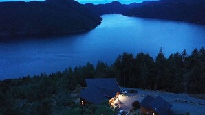 A lakeside property with a house and a dock. - Panoramic Suite  – Breathtaking Fjord View, Summit House. (Malahat)