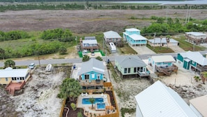 A coastal property with multiple houses, a swimming pool, and a beach area. - DOG-FRIENDLY, OUTDOOR POOL, DUPLEX BEACH HOUSE!! (Gulf Shores)