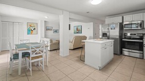 A modern kitchen with white cabinetry, a central island, and stainless steel appliances. - DOG-FRIENDLY, OUTDOOR POOL, DUPLEX BEACH HOUSE!! (Gulf Shores)