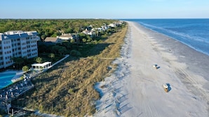 A beachside hotel with a long sandy beach, a pool, and a view of the ocean. - Guest Favorite~Steps to the beach~Pickleball and Tennis Courts~Beach Bar (Hilton Head Island)