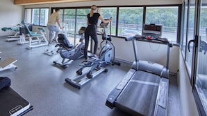 A gym with treadmills, elliptical machines, and a stationary bike. - Camping familial 4* | Mobil-home + Accès piscine (Monterblanc)