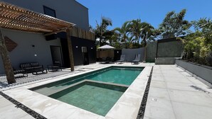 A modern outdoor pool area with two pools, lounge chairs, and a pergola. - Palulu Flats (São Sebastião)