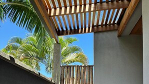 A wooden bench under a pergola with a view of palm trees. - Palulu Flats (São Sebastião)
