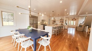 A spacious kitchen with a central island, white cabinetry, and a stainless steel refrigerator.