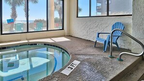 Un espace piscine doté d’une enceinte en verre, d’une chaise et d’un panneau indiquant une profondeur de 3 pieds.