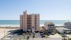 Un hotel a più piani con parcheggio e vista sulla spiaggia.