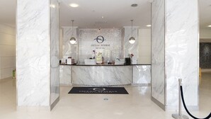 A reception area with marble walls and a reception desk. - Ocean Reserve (Sunny Isles Beach)