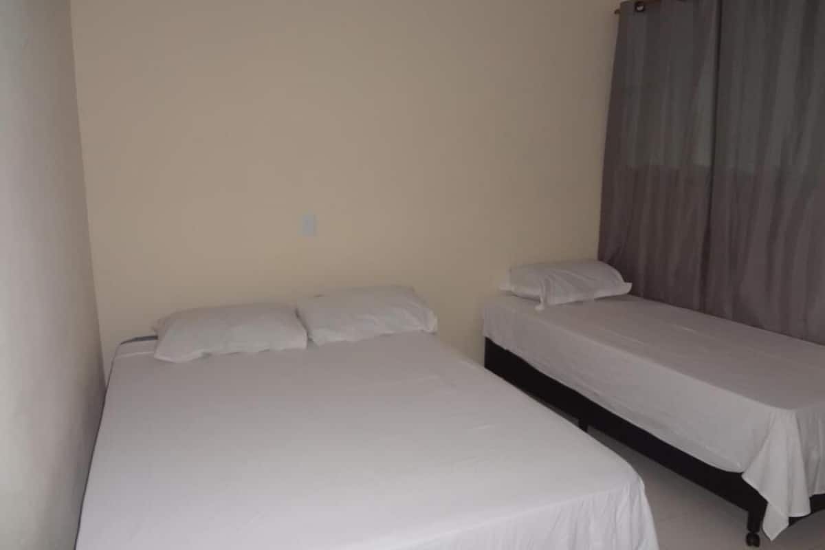 A room with two single beds, each with white bedding.