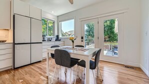 A modern kitchen with a dining area, large windows, and a view of the outdoors. - Modern Comfort in Central Park: 4BR Home in Denver (Denver)