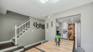 A modern kitchen with white cabinets, a built-in oven, and a refrigerator.