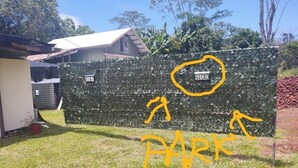 A fenced area with a sign reading "GECKO" and a yellow outline indicating a parking area.