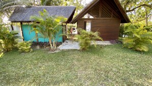 A small wooden cabin with a thatched roof, surrounded by lush tropical vegetation. - Freshwater Private Resort (Aore Island)