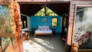 A room with a bed, a small table, and a wall with a picture. - Freshwater Private Resort (Aore Island)