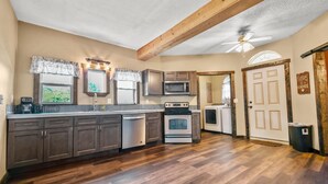 A kitchen with wooden cabinets, a microwave, an oven, and a dishwasher.
