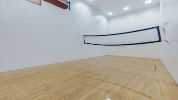 Una cancha de squash con piso de madera y una red.