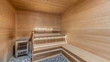 Una sauna con paredes y bancos de madera, piso de baldosas y un estante pequeño con objetos.