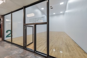 A glass door with a sign prohibiting food or drinks and requiring protective eyewear and shirts.
