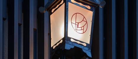 A traditional lantern with a geometric design on its glass, mounted on a metal pole.