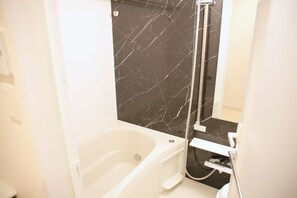 個別の浴槽とシャワー、ヘアドライヤー、ビデ、タオル