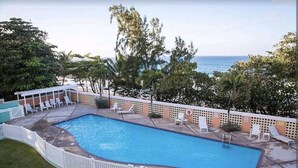 Una piscina con lettini e vista sull'oceano.