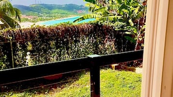 A view from a balcony with a wooden floor, a metal railing, and a clear sky.
