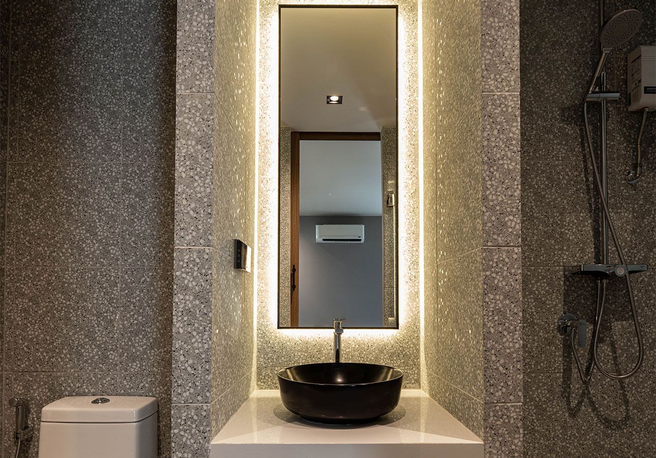 A modern bathroom with a large mirror, a vessel sink, and a shower.