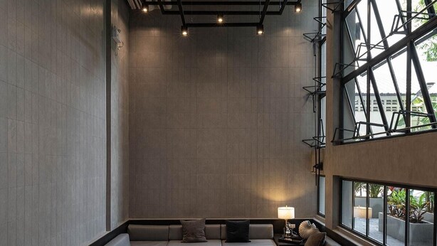 A modern interior with a central heated floor, seating area, and large windows offering views. - EXII Hotel Ngamwongwan (Nonthaburi)