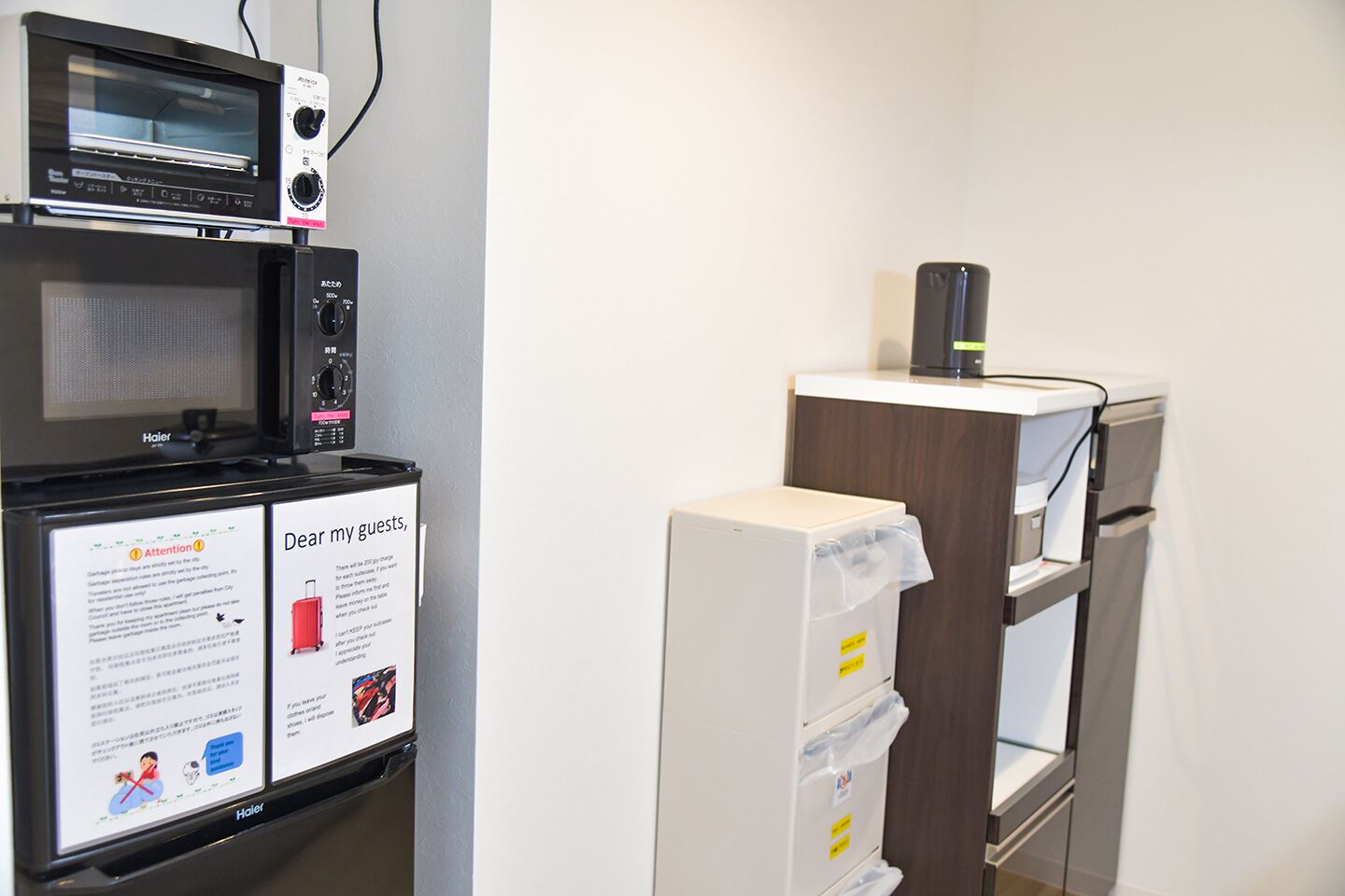 A hotel room with a microwave, a coffee machine, and a minibar. There is also a notice for guests.