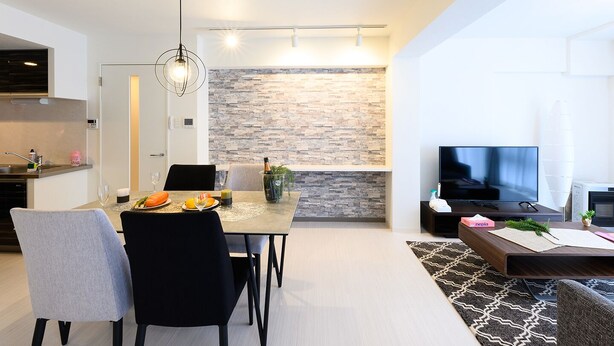 A modern living room with a dining area, a stone accent wall, a flat-screen TV, and a fireplace. - GLASS YAMAHANA EAST (Sapporo)