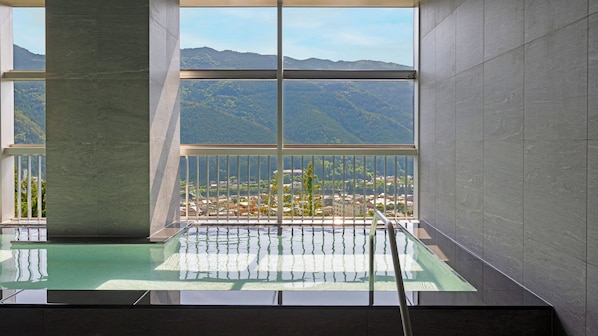 Una piscina interior moderna con vistas a un paisaje montañoso.