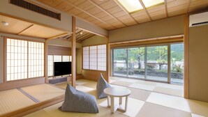 Perinteinen japanilainen huone, jossa on tatamimatto, televisio ja näkymä puutarhaan.