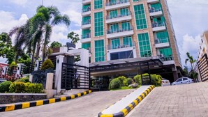 A tall, modern building with multiple floors, large windows, and a gated entrance. - The Padgett Suites Cebu (Cebu City)
