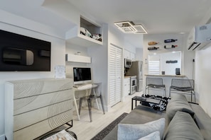 Relax in this stylish living space with a flat-screen TV, computer desk, and comfortable sofa.