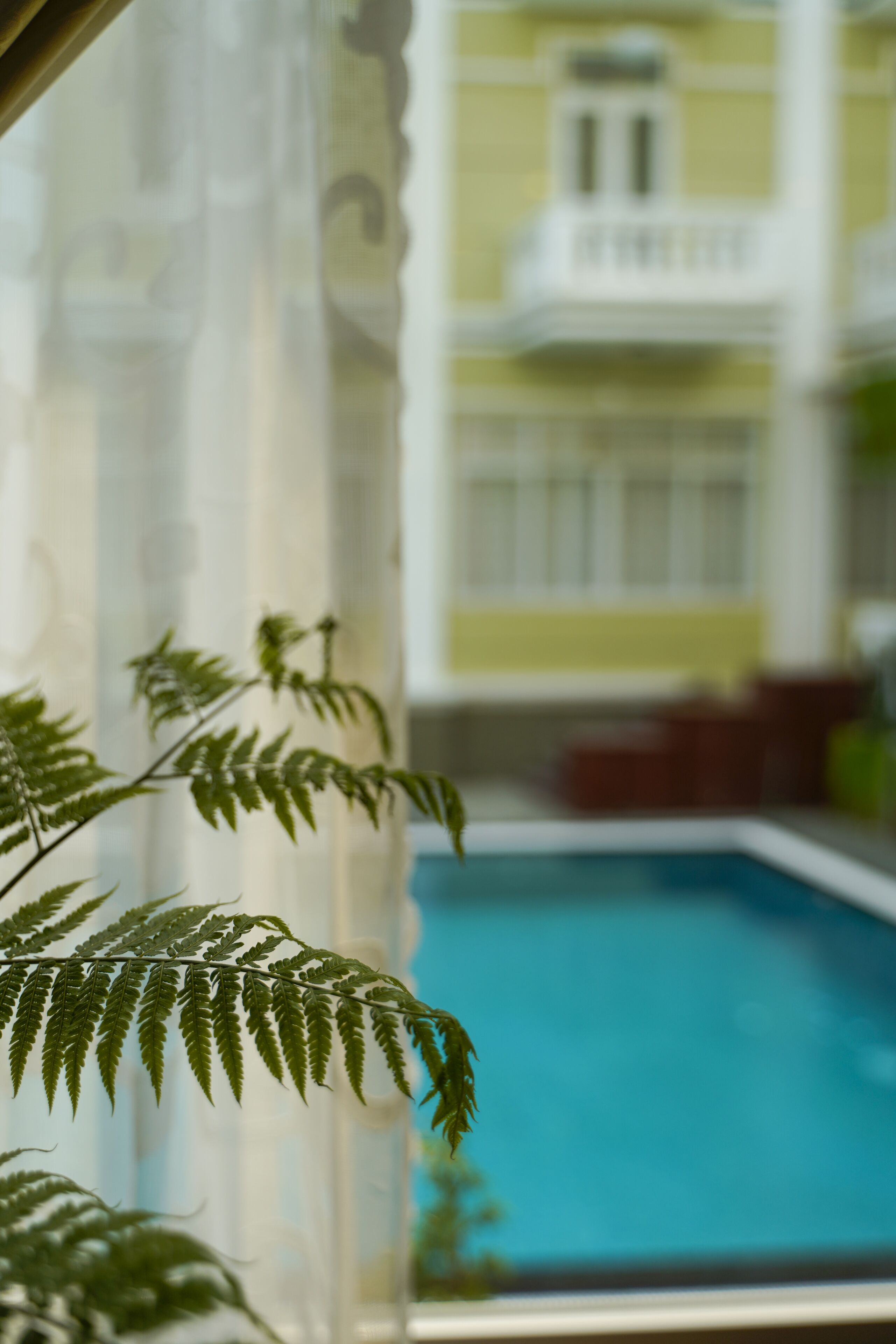 A pool area with a view of a building in the background.
