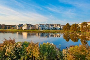 Stunning lakeside homes with gabled roofs and large windows, set amidst lush greenery and a serene lake.