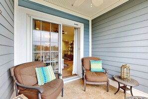 Relax in a serene outdoor seating area with two comfortable chairs and a small table.