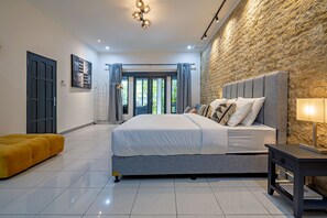 Ein modernes Schlafzimmer mit einem großen Bett, einer Wand aus Stein und einem hellen, gut beleuchteten Raum.